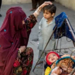 Afghan refugee comforts her children